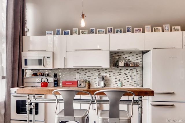 a view of kitchen with stainless steel appliances granite countertop refrigerator sink and cabinets