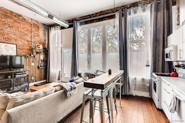 a living room with furniture a flat screen tv and a window