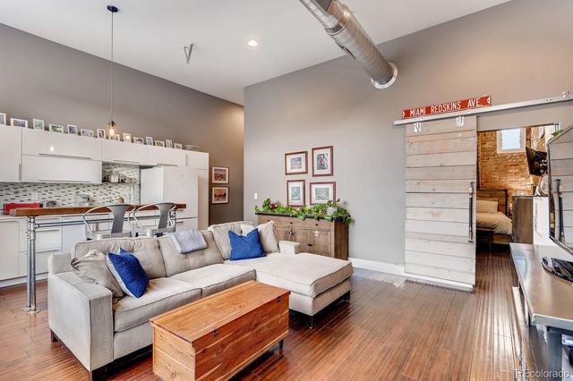 a living room with furniture and a wooden floor