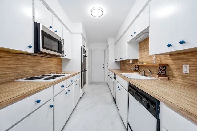a large kitchen with stainless steel appliances granite countertop a stove and a sink