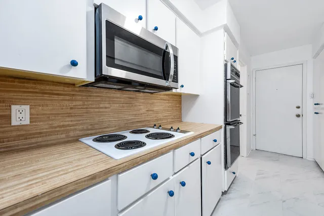 a kitchen with stainless steel appliances granite countertop a stove and a microwave