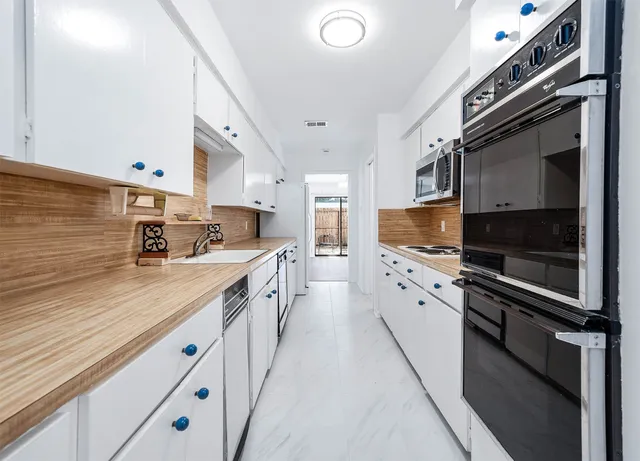 a kitchen with stainless steel appliances granite countertop a sink and cabinets