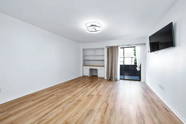 a view of a livingroom with wooden floor and a fireplace