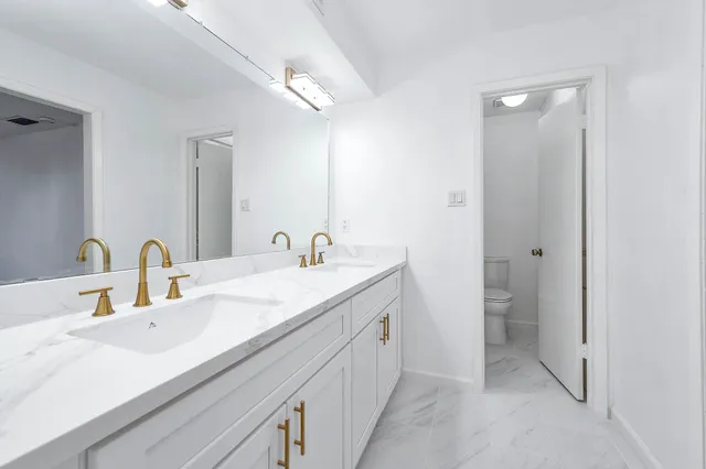 a white toilet sitting next to a white wall