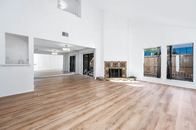 an empty room with wooden floor and fireplace