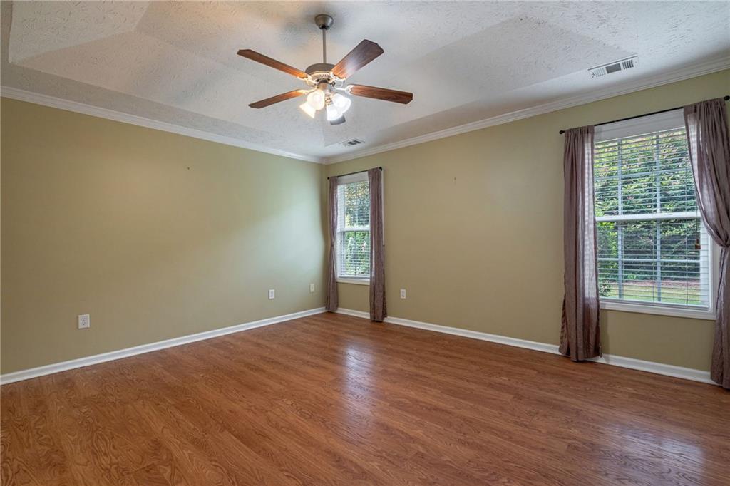 245 Memory Lane Winder, GA 30680 - Photo 23 of 62 an empty room with wooden floor chandelier fan and windows