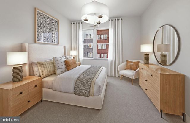 a spacious bedroom with a bed a mirror and a large window