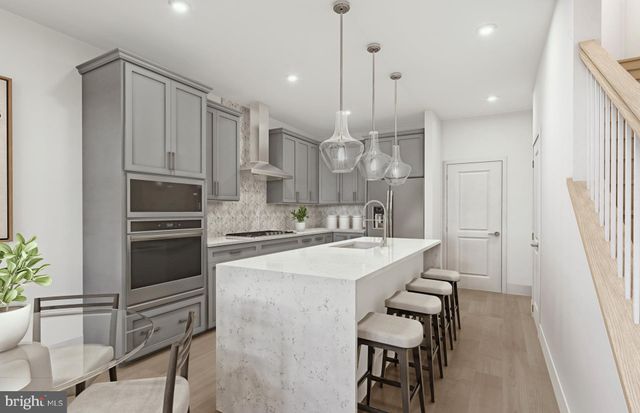 a kitchen with a sink stainless steel appliances and white cabinets