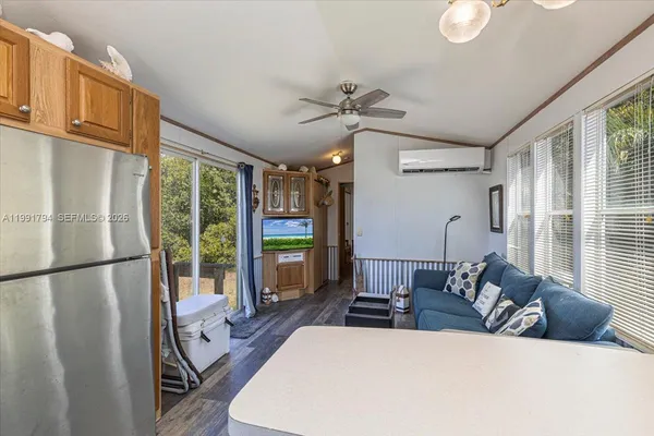 a living room with furniture a flat screen tv and a large window