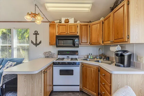 a kitchen with a stove a sink and a microwave