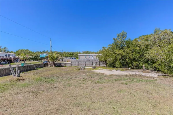 a view of a backyard and basketball court