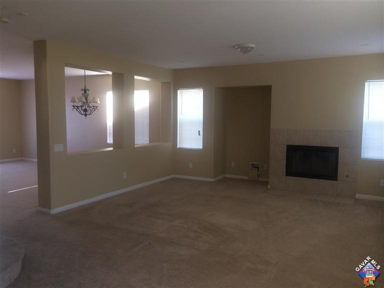 43757 Rucker Street Lancaster, CA 93535 - Photo 3 of 8 an empty room with windows and fireplace
