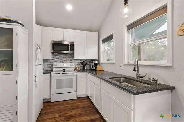 a kitchen with stainless steel appliances a sink stove and refrigerator