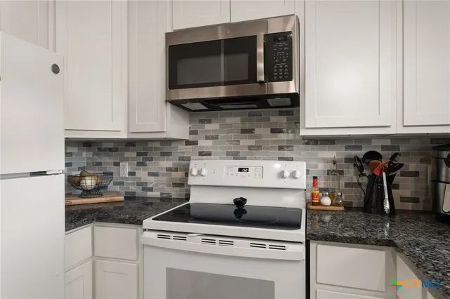 a kitchen with stainless steel appliances granite countertop a stove and a microwave