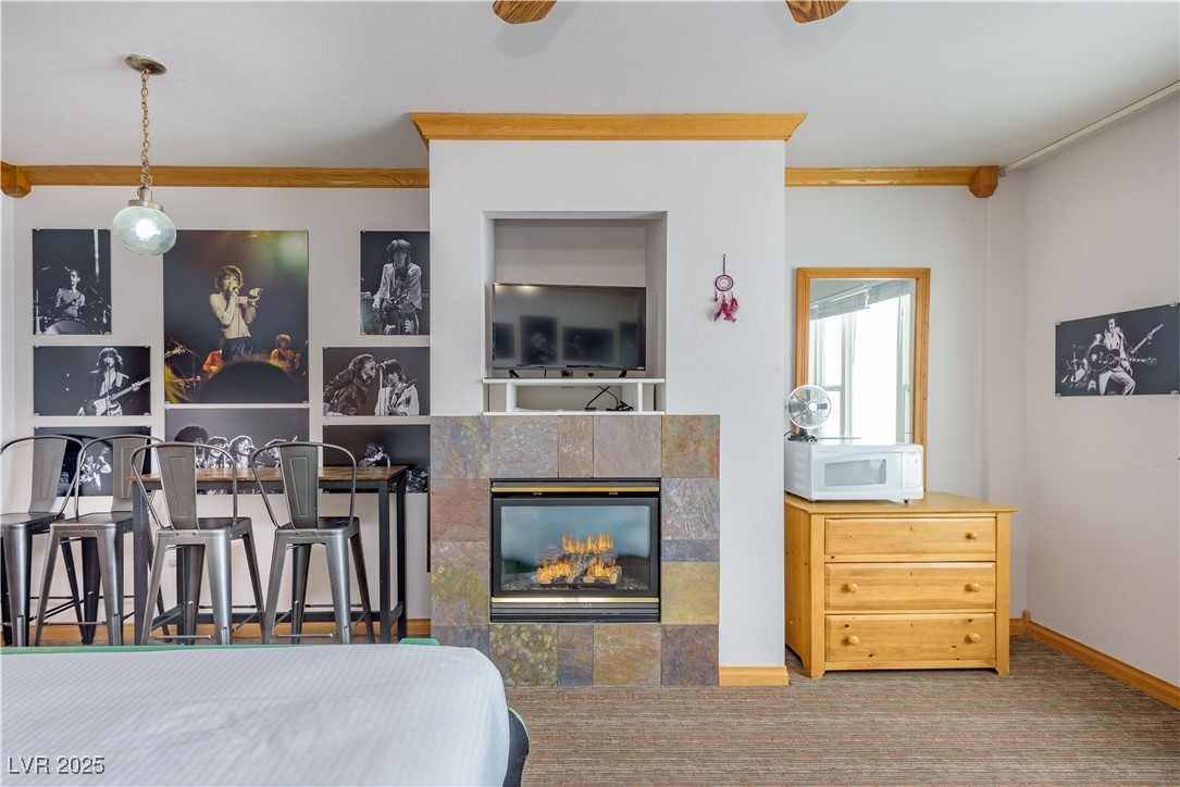 223 Hunter Ridge Drive, Unit 2303 Brian Head, UT 84719 - Photo 7 of 31 Bedroom with carpet flooring, a tiled fireplace, crown molding, and a ceiling fan