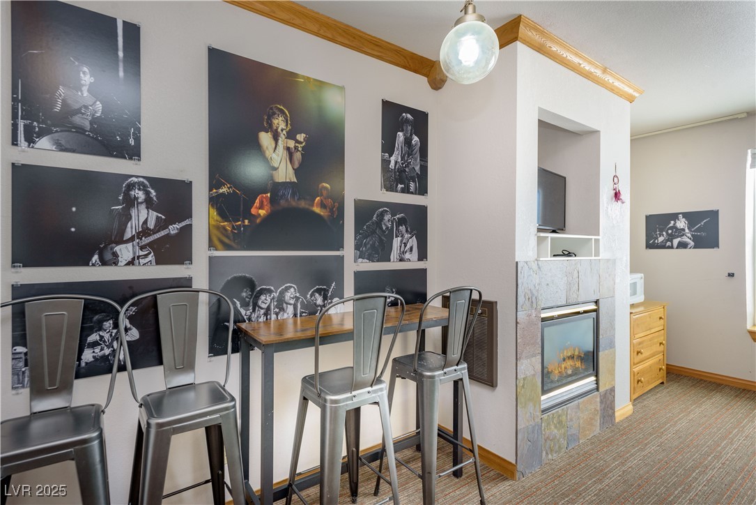 223 Hunter Ridge Drive, Unit 2303 Brian Head, UT 84719 - Photo 9 of 31 Bar area with built in features, a fireplace, light colored carpet, ornamental molding, and wooden counters