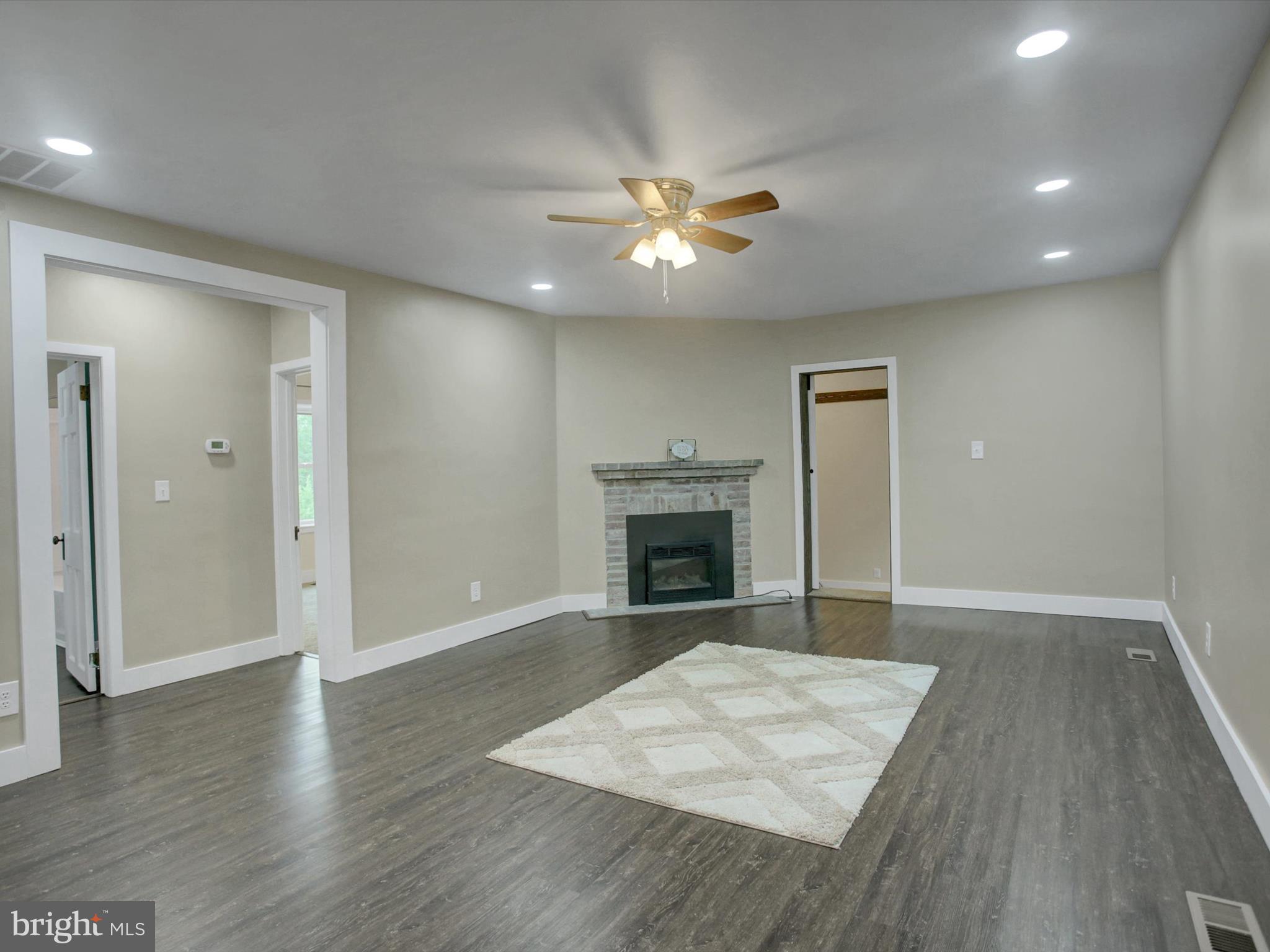 3043 Emmitsburg Road Gettysburg, PA 17325 - Photo 7 of 48 an empty room with wooden floor fireplace and ceiling fan