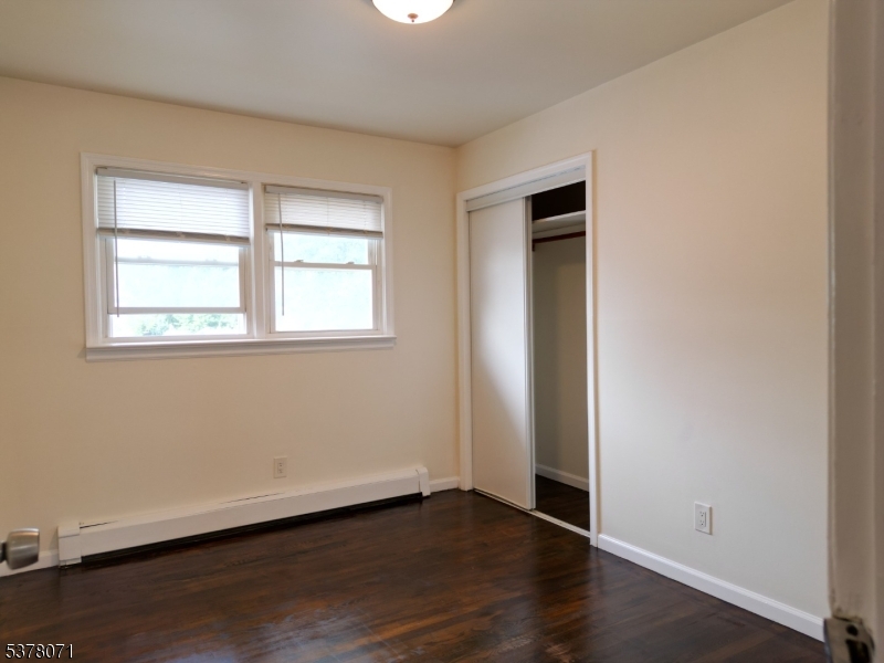104 Eastern Way, Unit 2 Rutherford, NJ 07070 - Photo 16 of 18 an empty room with wooden floor and windows
