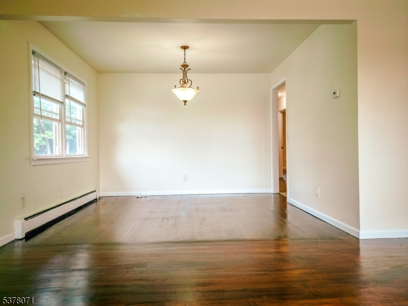 104 Eastern Way, Unit 2 Rutherford, NJ 07070 - Photo 9 of 18 an empty room with wooden floor chandelier and windows