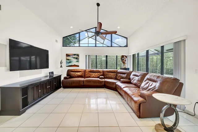 a living room with furniture a flat screen tv and a large window