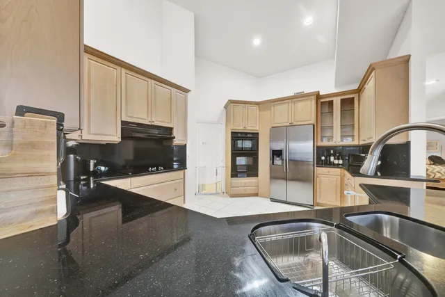 a kitchen with granite countertop a sink and stainless steel appliances