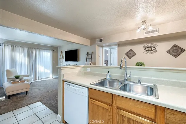 a kitchen with a sink dishwasher a stove and a dining table with wooden floor