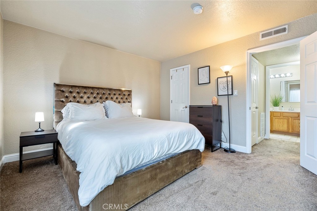 2881 Huntington Boulevard, Unit 137 Fresno, CA 93721 - Photo 18 of 30 a bedroom with a bed and a lamp