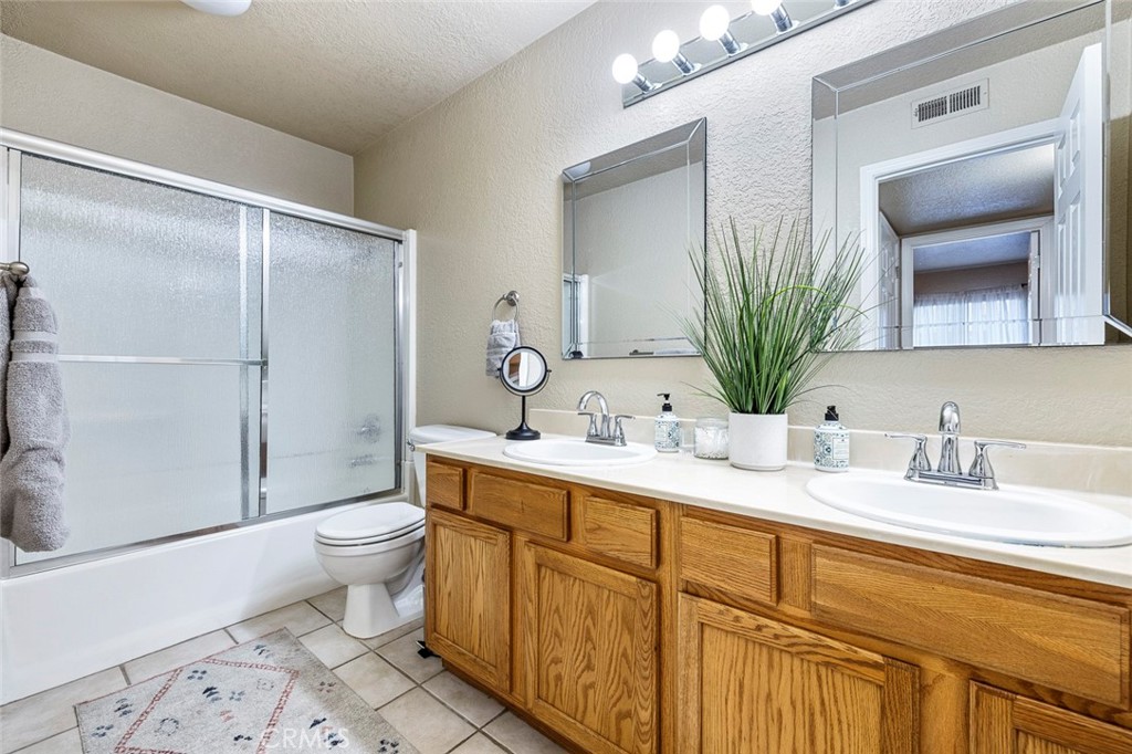 2881 Huntington Boulevard, Unit 137 Fresno, CA 93721 - Photo 20 of 30 a bathroom with a granite countertop sink toilet and mirror