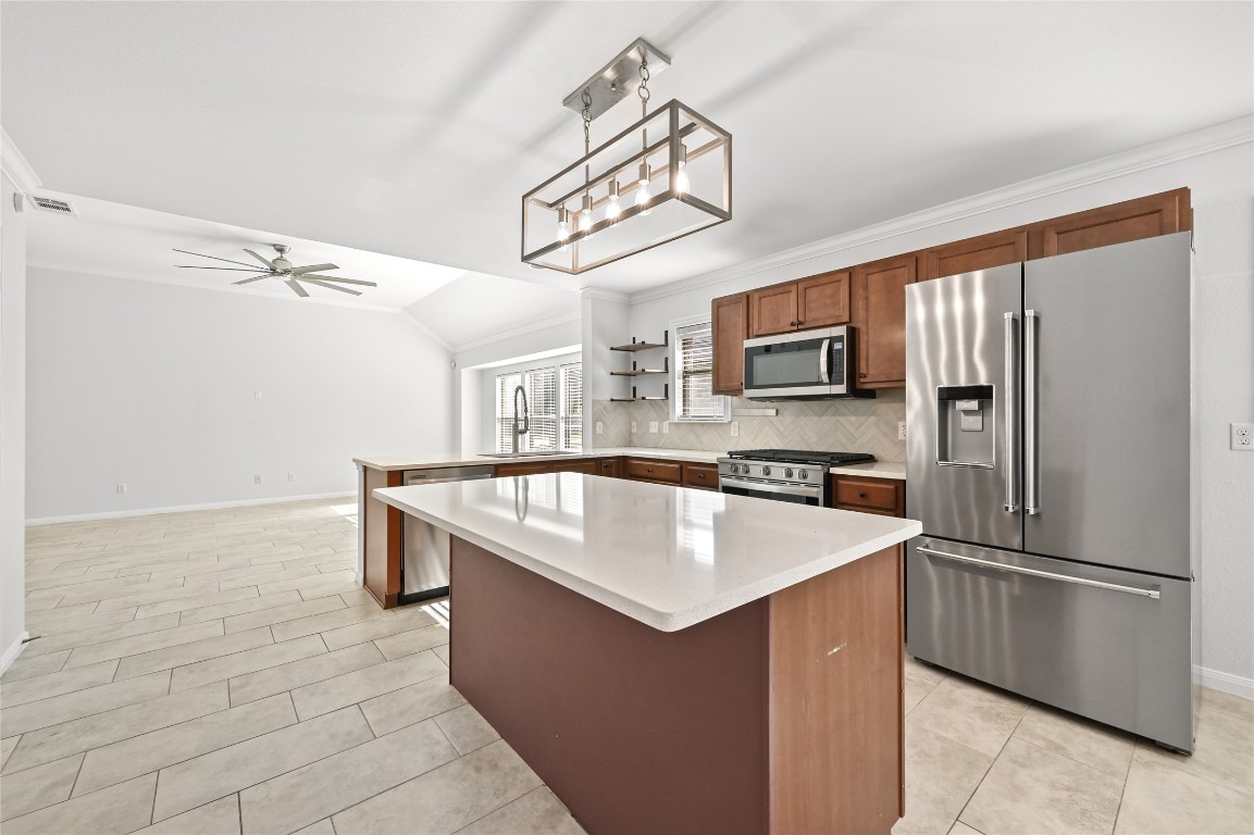6909 Bay City Bend Austin, TX 78725 - Photo 17 of 37 a kitchen with stainless steel appliances granite countertop a refrigerator a sink a stove top oven and a refrigerator