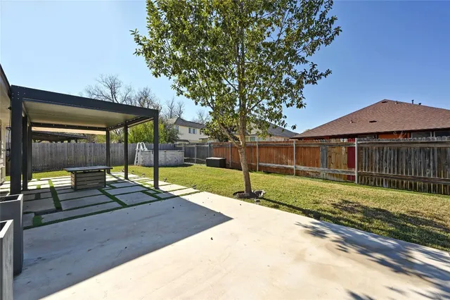 a view of a backyard with wooden fence