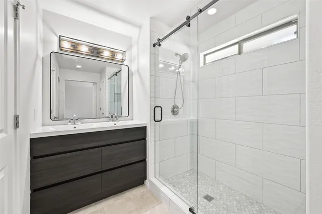 a bathroom with a shower sink and mirror