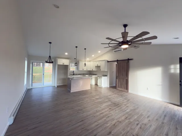 a view of kitchen with refrigerator stove and wooden floor