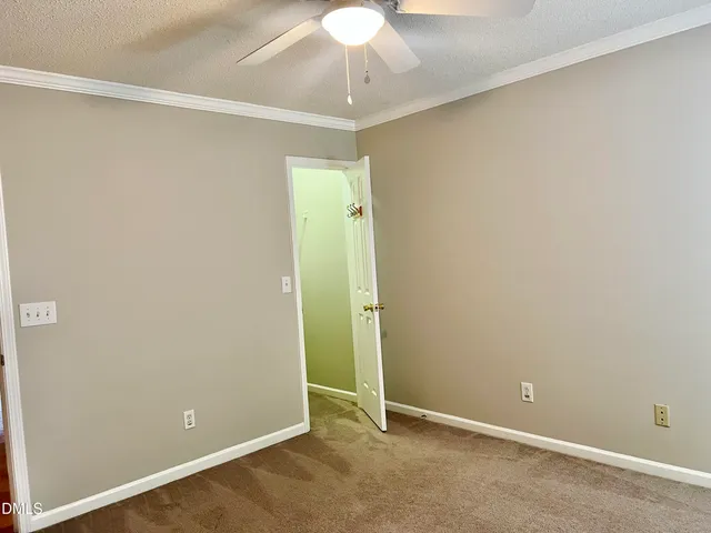 an empty room with a chandelier fan and closet