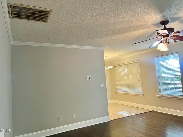 a view of a room with wooden floor and ceiling fan