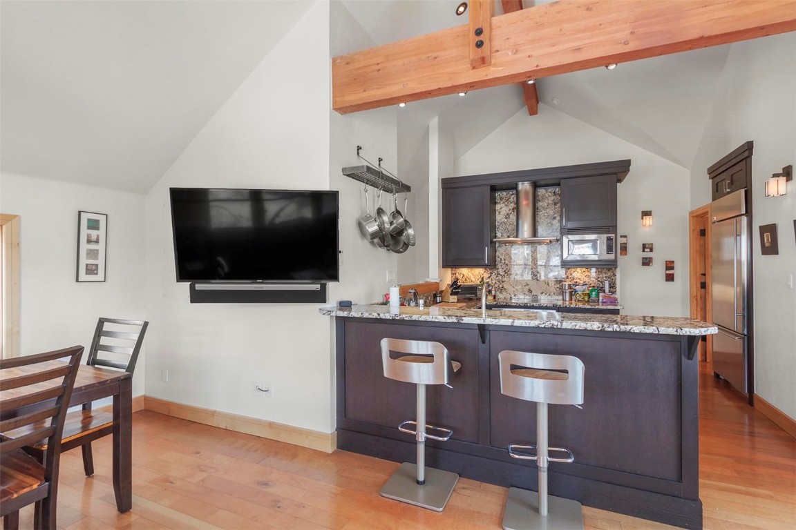 217 South Ridge Street, Unit 3 Breckenridge, CO 80424 - Photo 6 of 21 a kitchen with stainless steel appliances granite countertop a table chairs and a refrigerator