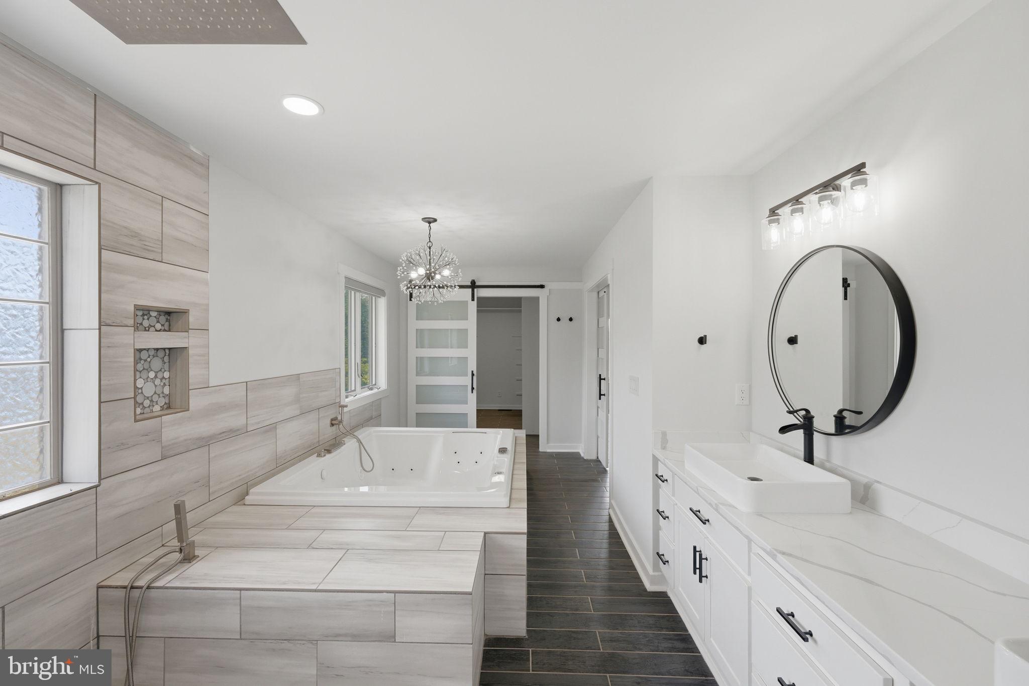 7522 Stubbs Bridge Road Spotsylvania, VA 22551 - Photo 23 of 60 a spacious bathroom with a tub sink and mirror