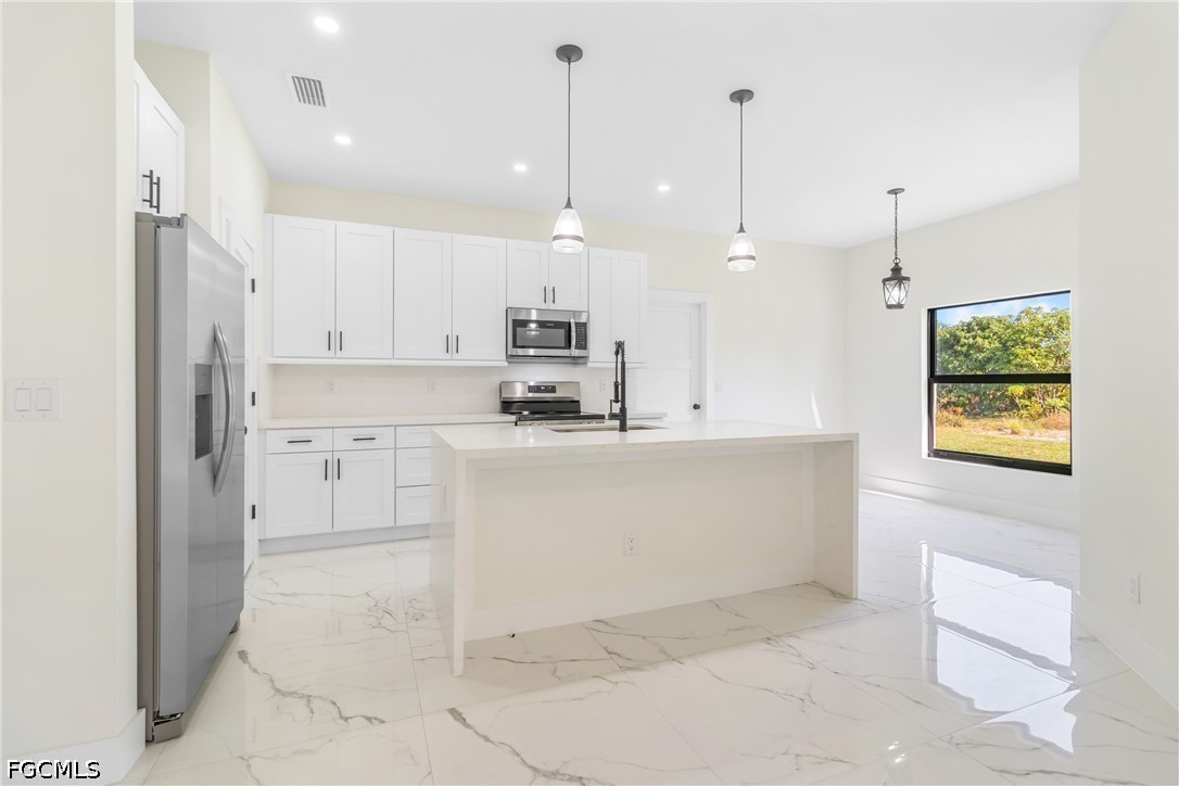 412 Fitch Avenue Lehigh Acres, FL 33972 - Photo 11 of 50 a view of kitchen with kitchen island white cabinets and stainless steel appliances
