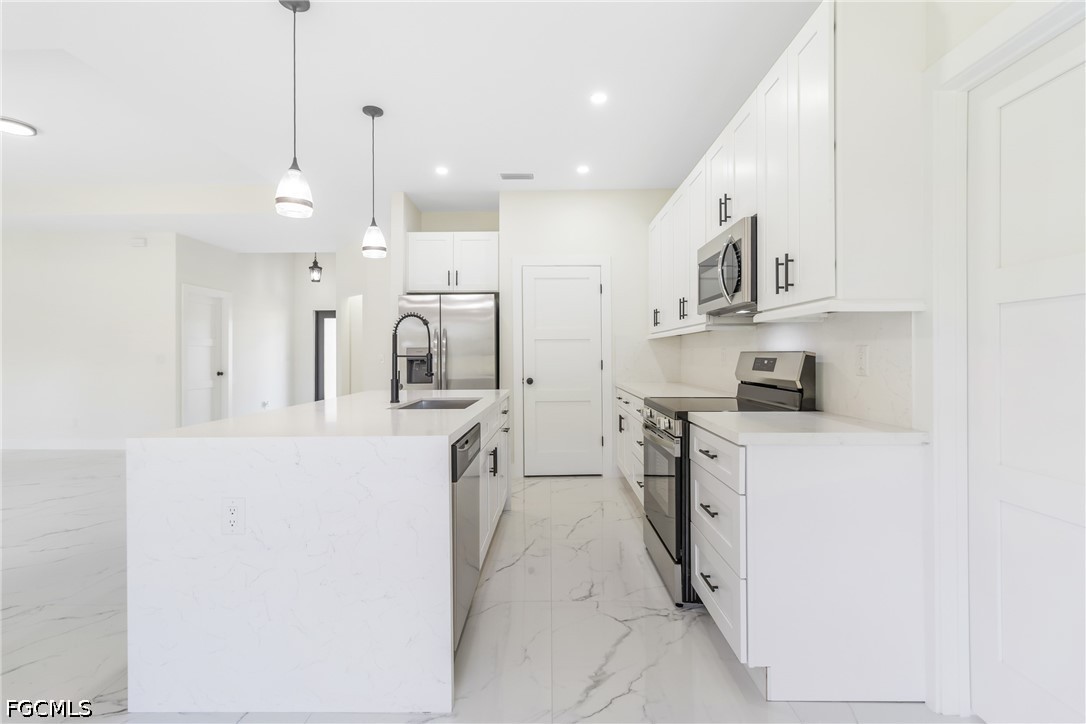 412 Fitch Avenue Lehigh Acres, FL 33972 - Photo 13 of 50 a kitchen with stainless steel appliances kitchen island a sink a stove and a refrigerator