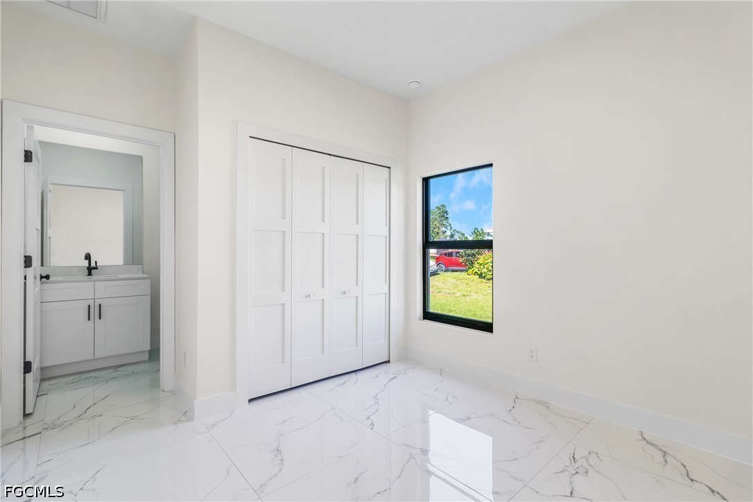 412 Fitch Avenue Lehigh Acres, FL 33972 - Photo 21 of 50 a view of a hallway with bathroom and mirror