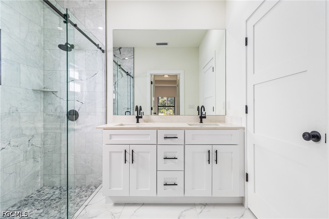 412 Fitch Avenue Lehigh Acres, FL 33972 - Photo 36 of 50 a spacious bathroom with a granite countertop sink a mirror and shower