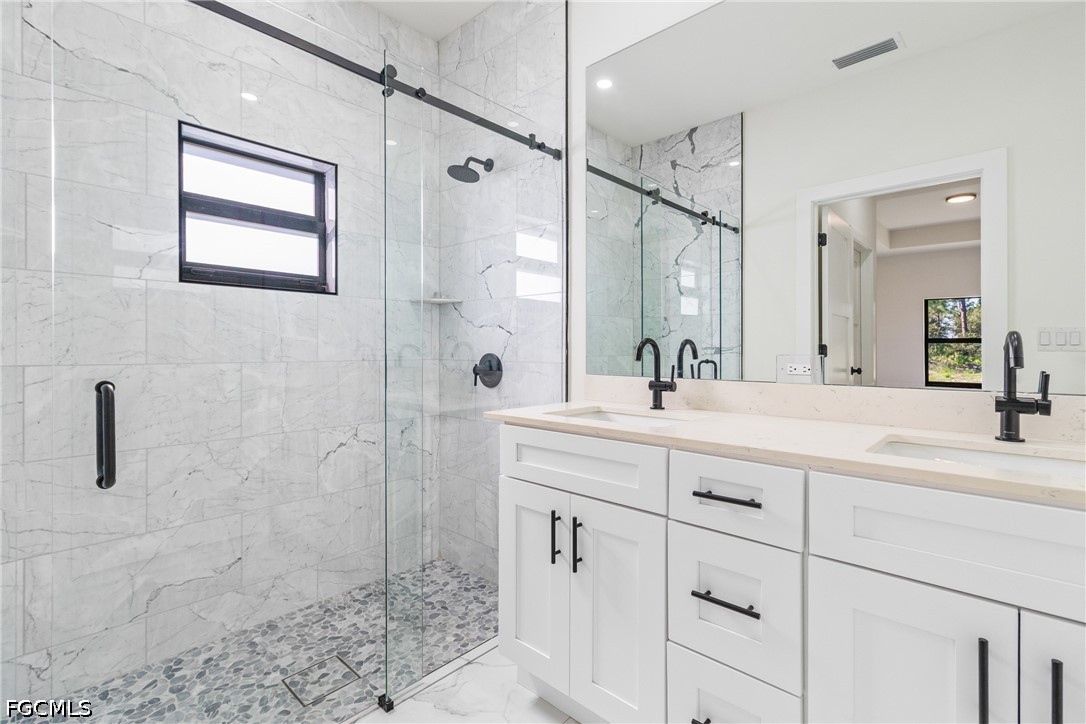 412 Fitch Avenue Lehigh Acres, FL 33972 - Photo 37 of 50 a bathroom with a shower sink and mirror