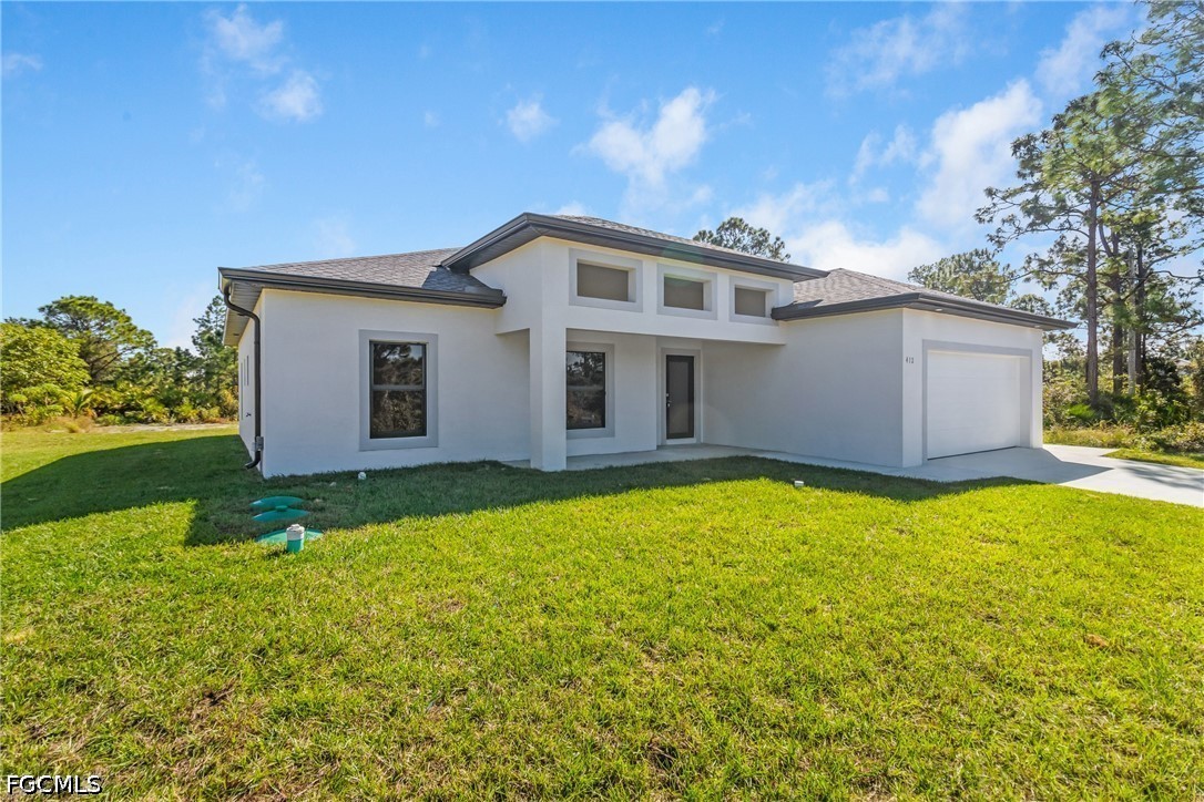 412 Fitch Avenue Lehigh Acres, FL 33972 - Photo 4 of 50 a backyard of a house with large trees and plants