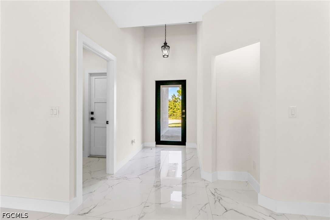 412 Fitch Avenue Lehigh Acres, FL 33972 - Photo 5 of 50 a view of a hallway with wooden floor and a bathroom