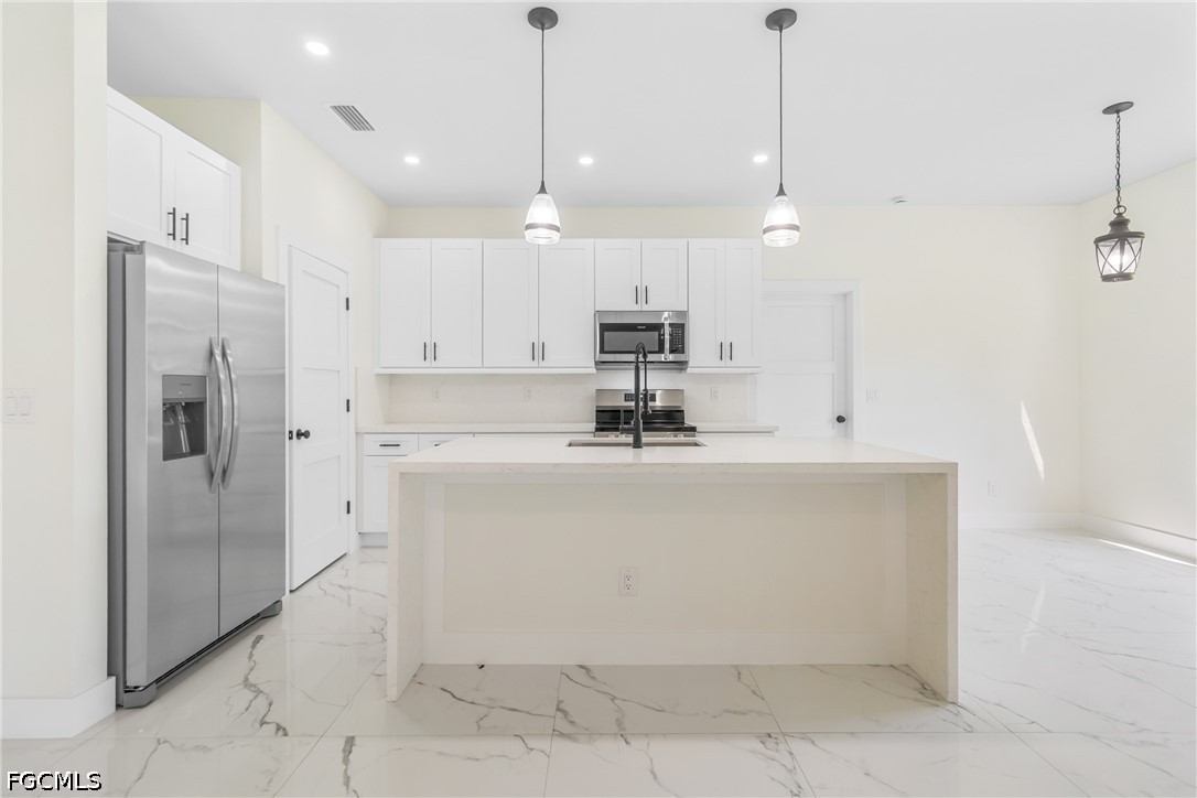 412 Fitch Avenue Lehigh Acres, FL 33972 - Photo 10 of 50 a view of a kitchen with stainless steel appliances granite countertop a refrigerator a oven and a sink
