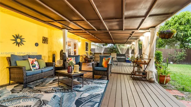 a living room with patio furniture and a garden