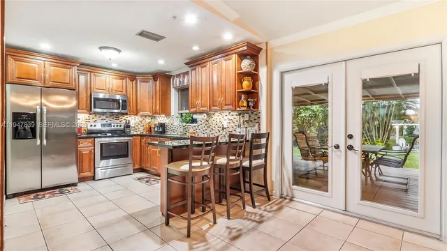 a kitchen with stainless steel appliances a table and chairs