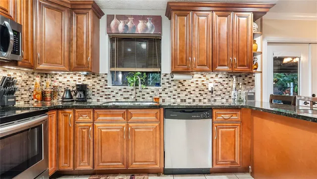 a kitchen with stainless steel appliances granite countertop wooden cabinets a sink and dishwasher