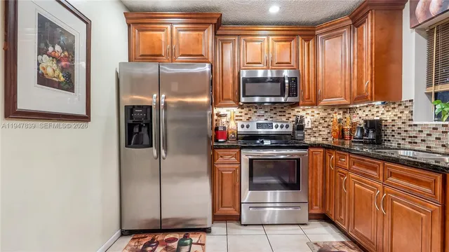 a kitchen with stainless steel appliances granite countertop a refrigerator and a sink