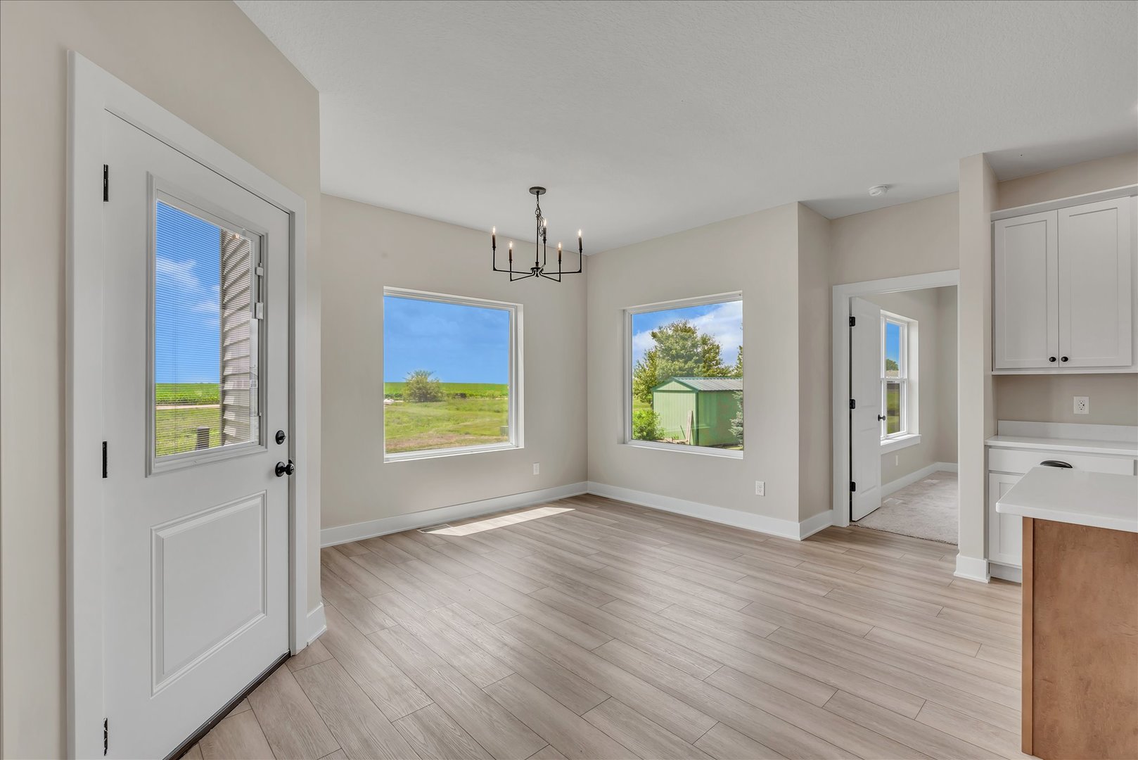 455 Rhonda Road New Liberty, IA 52765 - Photo 26 of 54 an empty room with wooden floor chandelier and windows