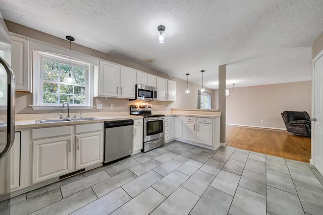 a kitchen with white cabinets and appliances